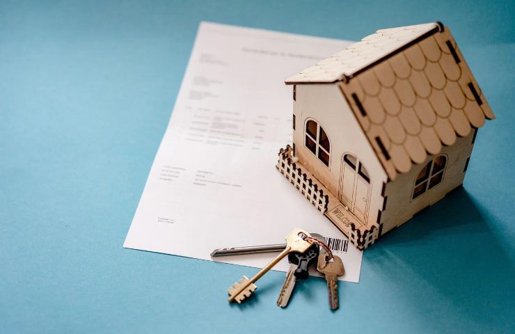 Modello di casa con documento e mazzo di chiavi