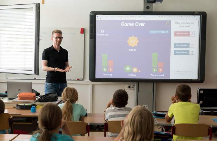 Un giovane maestro durante una lezione ai bambini