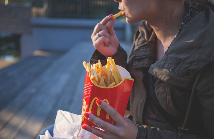 Una donna mangia patatine del McDonald's