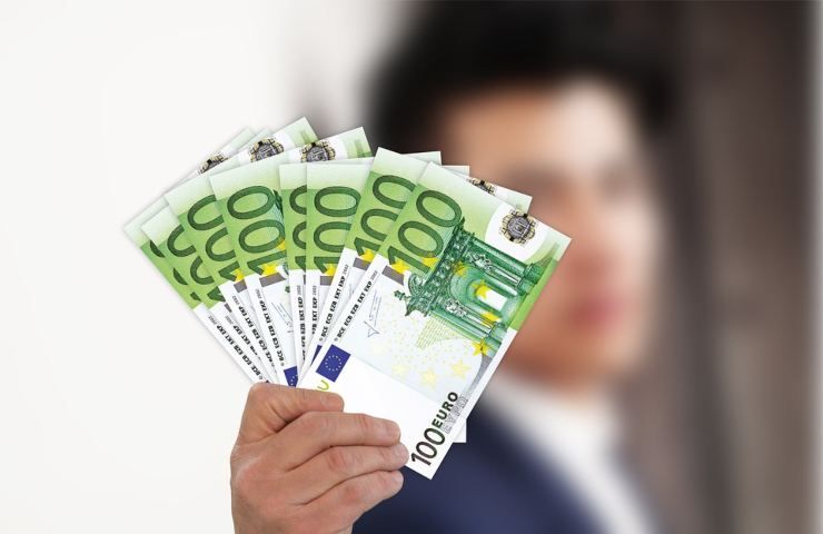 Una persona sfodera diverse banconote da 100 euro