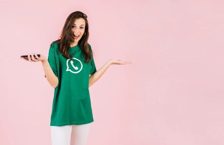 Una ragazza che indossa una t-shirt verde con il logo di Whatsapp