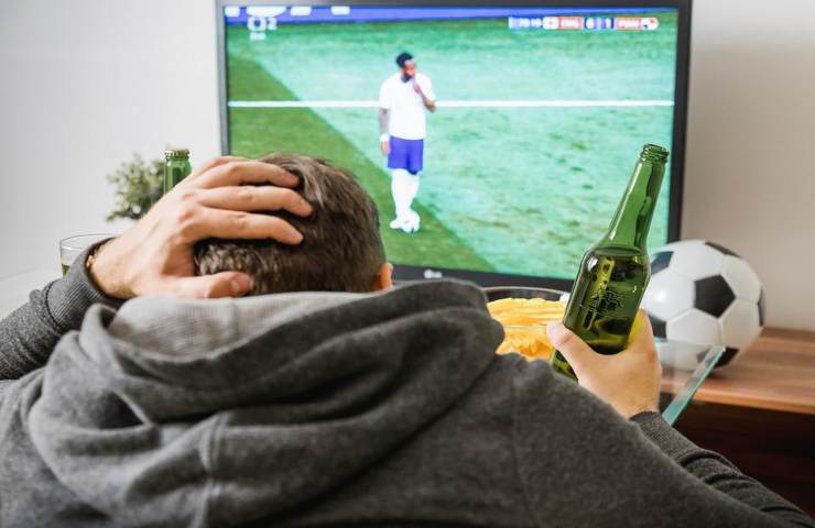 Un uomo guarda il calcio in tv