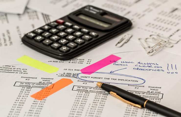 Una calcolatrice e dei documenti per il calcolo delle tasse