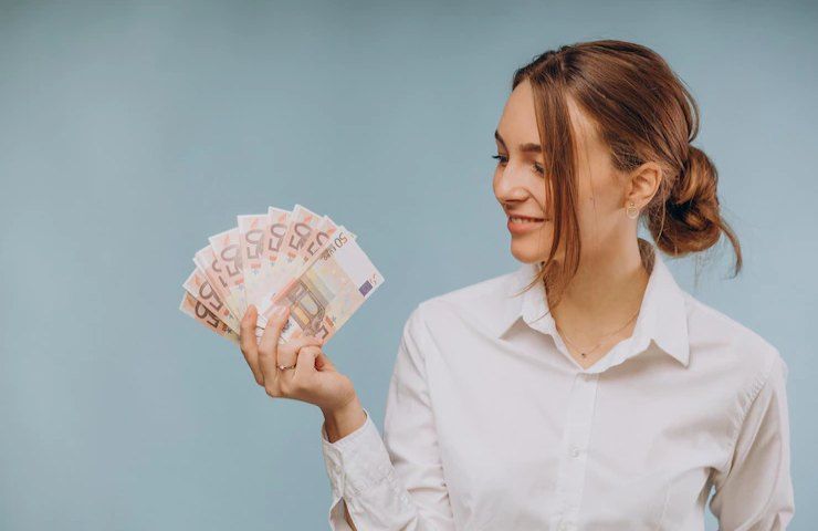 Una donna felice con tante banconote di grosso taglio