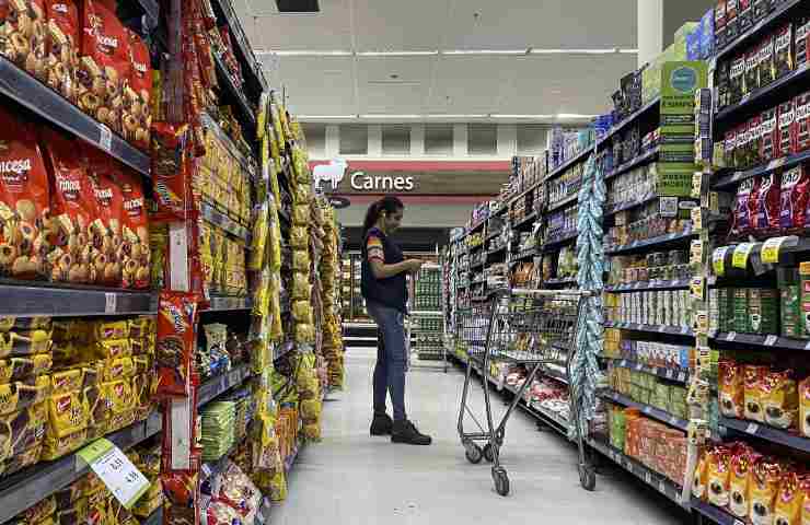 Una donna intenta a fare la spesa al supermercato