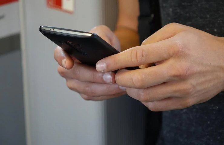 Una persona mentre utilizza il proprio smartphone